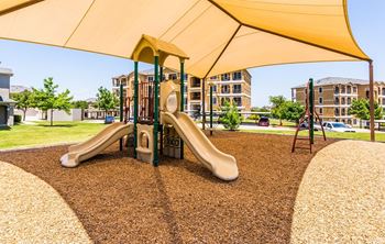 A playground with a yellow slide and a yellow canopy.