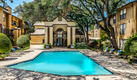 A swimming pool surrounded by a fence and trees.
