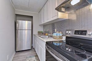 A kitchen with a stove top oven and a refrigerator.