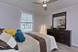 A bedroom with a bed, dresser, and mirror.