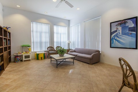 A living room with a couch, chair, and a painting on the wall.