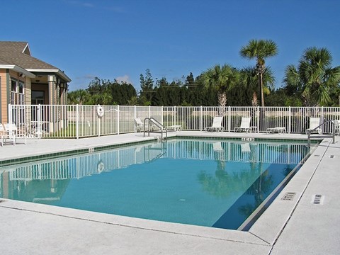 A swimming pool surrounded by a white fence.