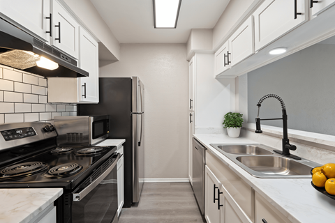 A kitchen with a black stove top oven and a black refrigerator.