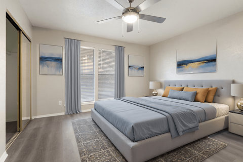 A bedroom with a large bed and a ceiling fan.