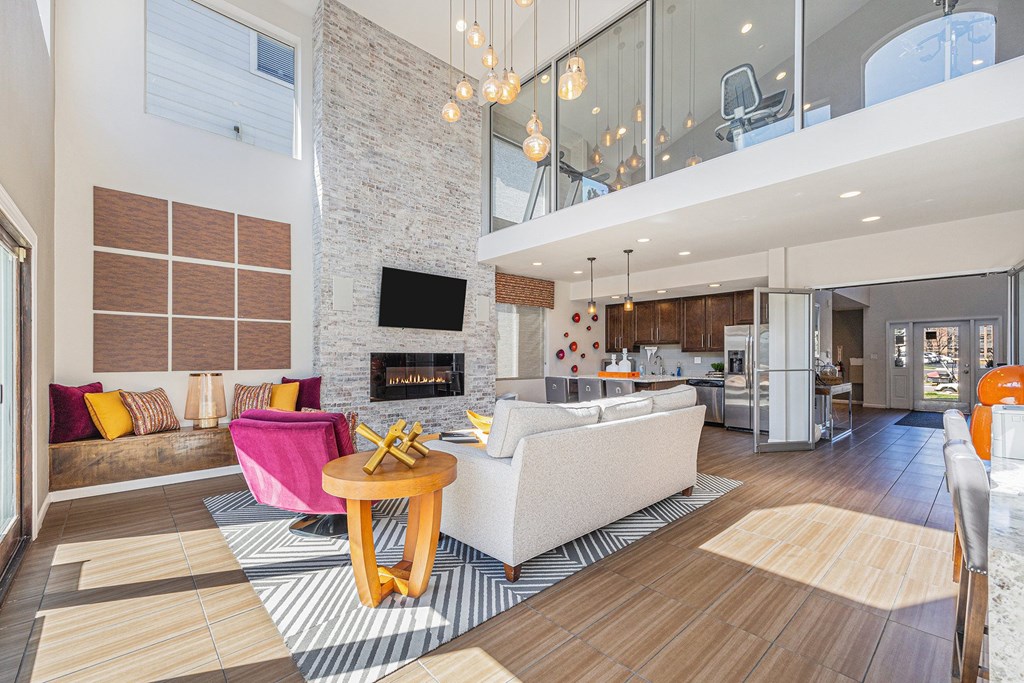 A modern living room with a stone fireplace and a white couch.