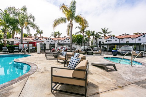 a resort style pool with chairs and palm trees