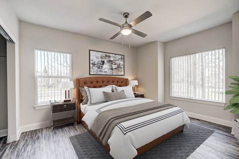 A bedroom with a large bed and a ceiling fan.