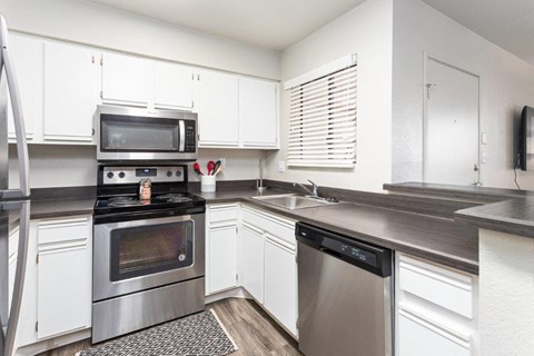 a kitchen with stainless steel appliances and white cabinets