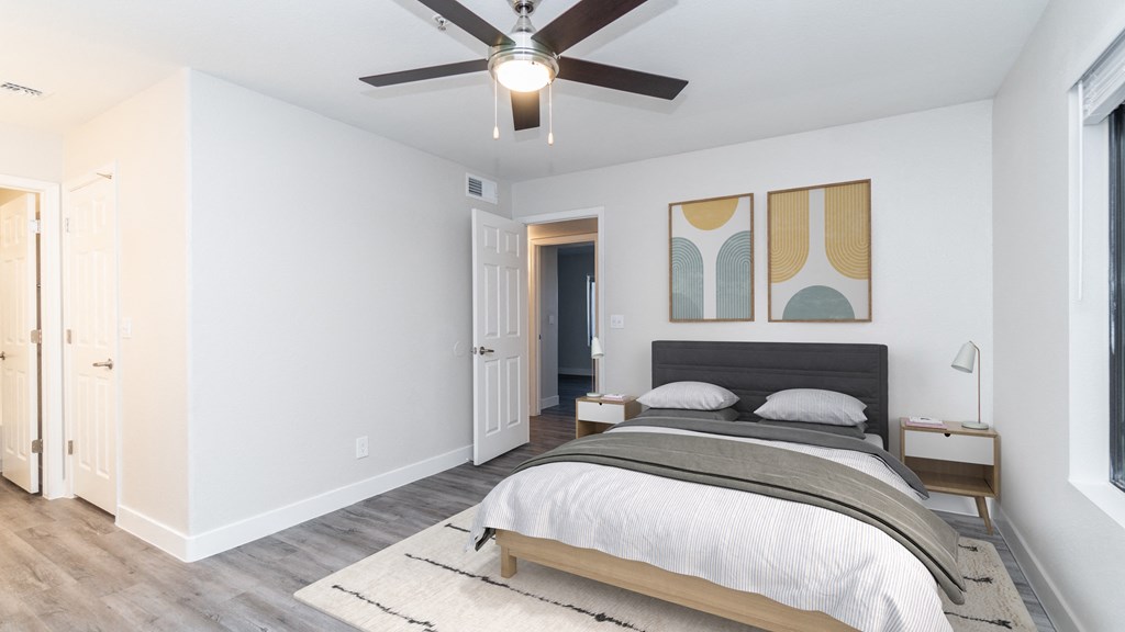 a bedroom with a large bed and a ceiling fan