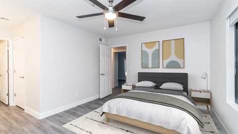 a bedroom with a large bed and a ceiling fan