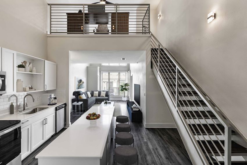 a kitchen and living room with a staircase in the background - Photo Gallery