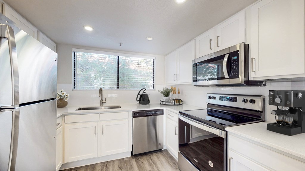 a kitchen with white cabinets and stainless steel appliances