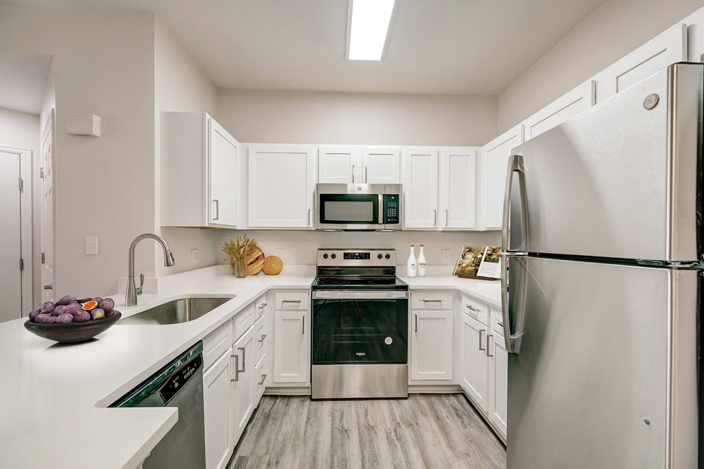 a kitchen with stainless steel appliances and white cabinets