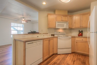 a kitchen with wooden cabinets and white appliances