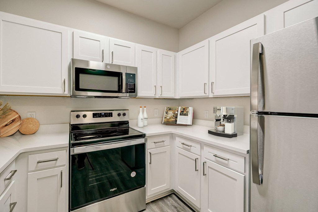 a kitchen with stainless steel appliances and white cabinets