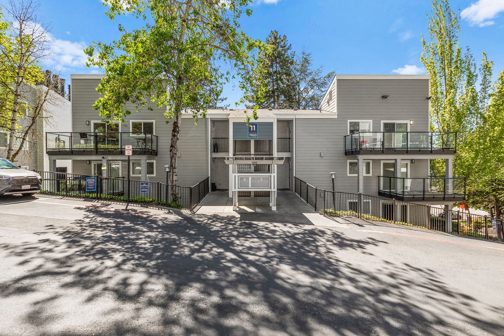 an apartment building with a parking lot and trees