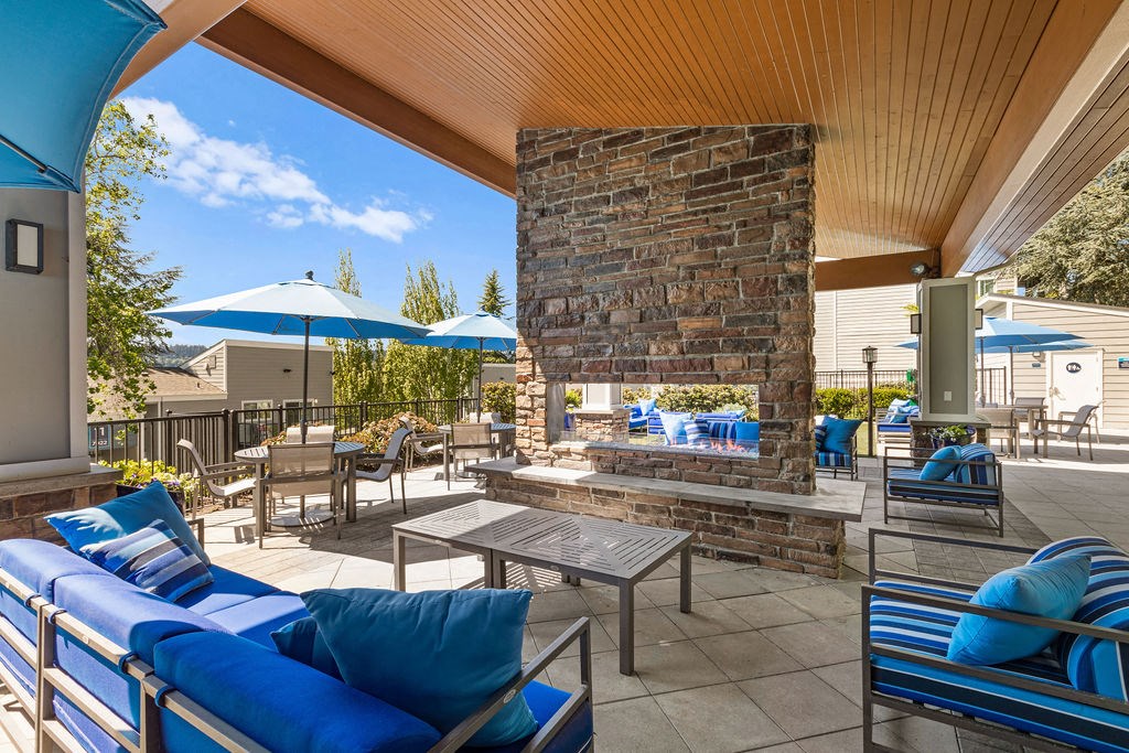 the outdoor patio has a fireplace and tables with umbrellas