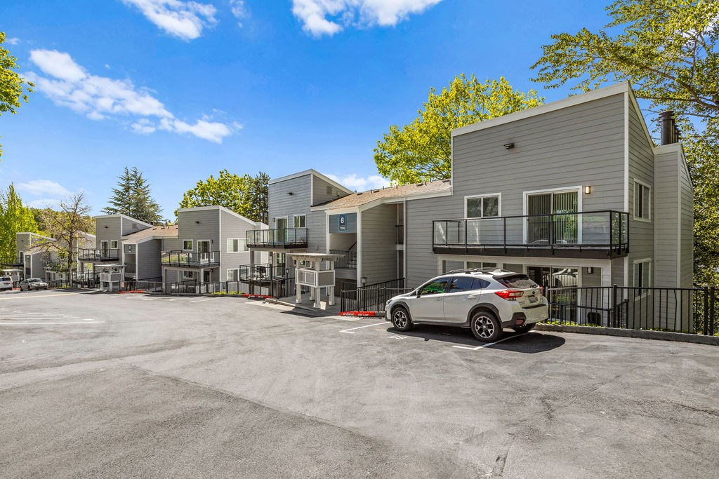 a car parked in a parking lot in front of apartment buildings