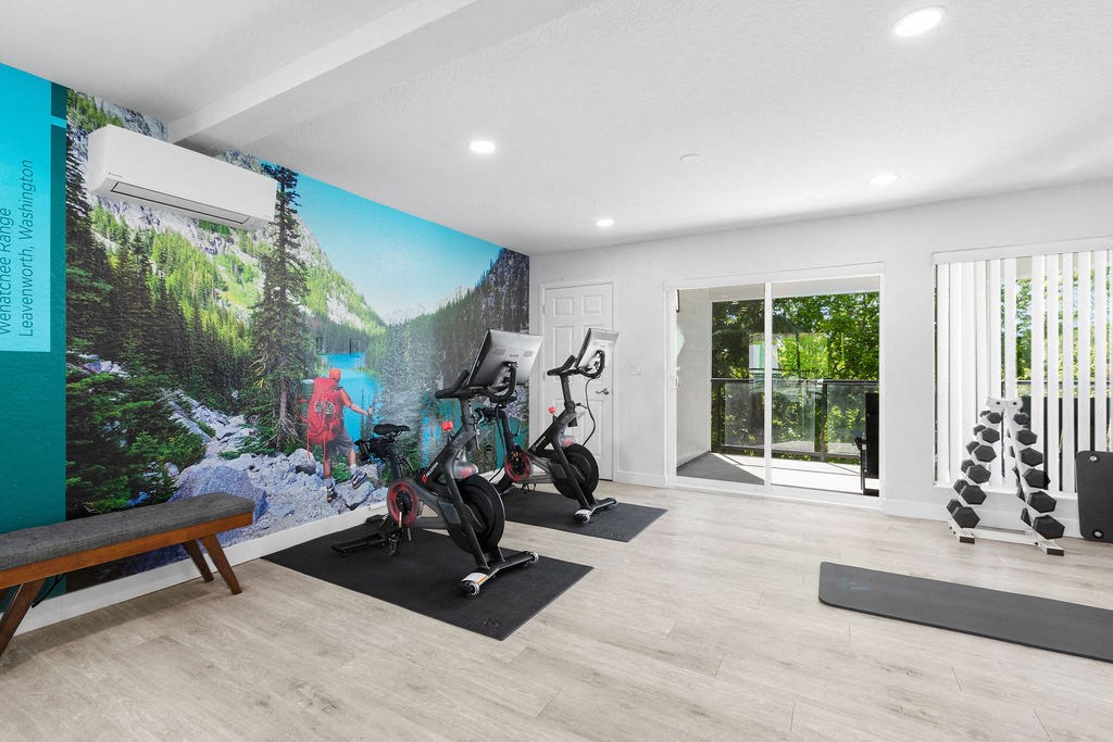 the home has a workout room with a wall mural and yoga equipment