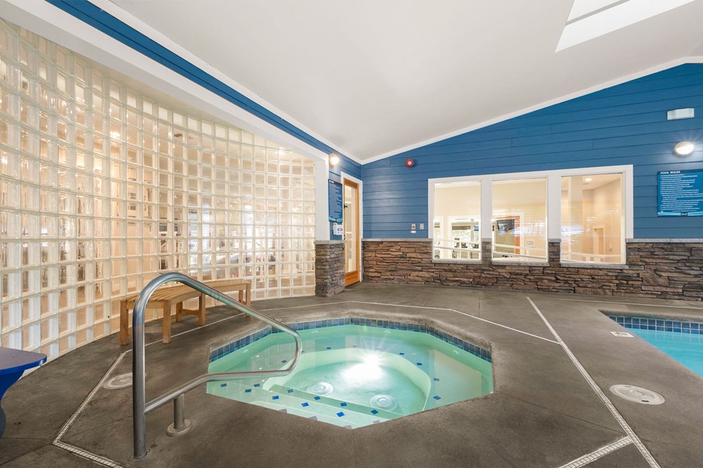 a spa with a pool and a glass walled jacuzzi