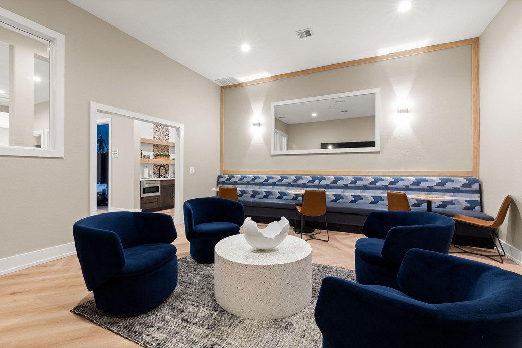 A living room with blue chairs and a white coffee table.