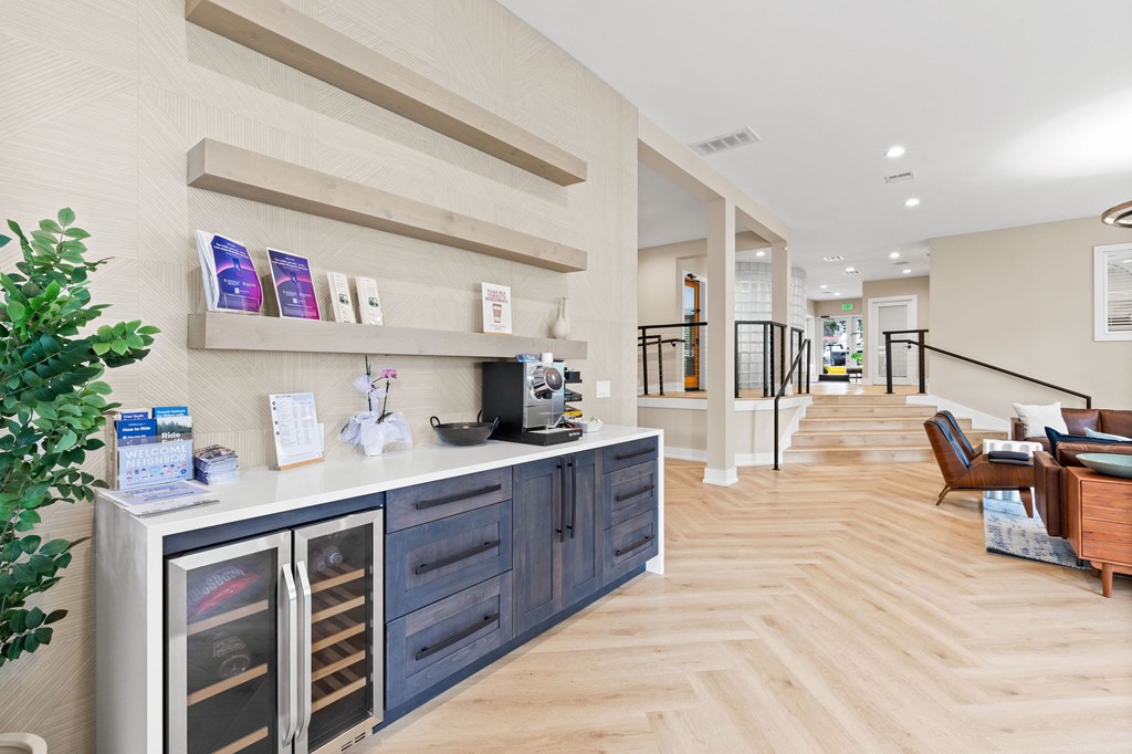 A modern kitchen with a wooden floor and a white wall.