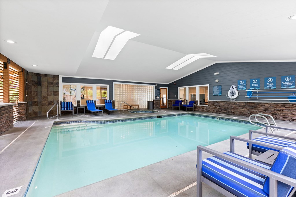 A large indoor swimming pool with a diving board.