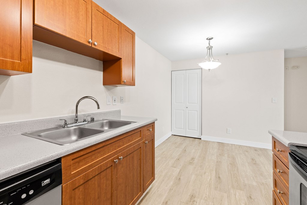 A kitchen with wooden cabinets and a white sink.
