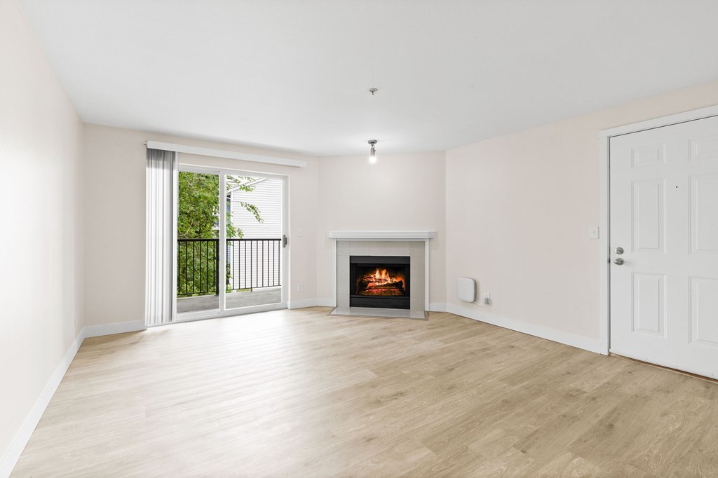 A room with a fireplace and sliding glass doors.