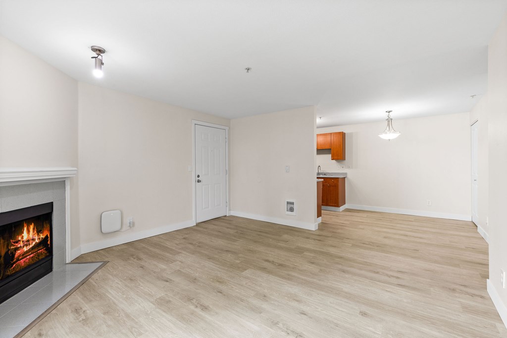 A room with a fireplace and wooden flooring.