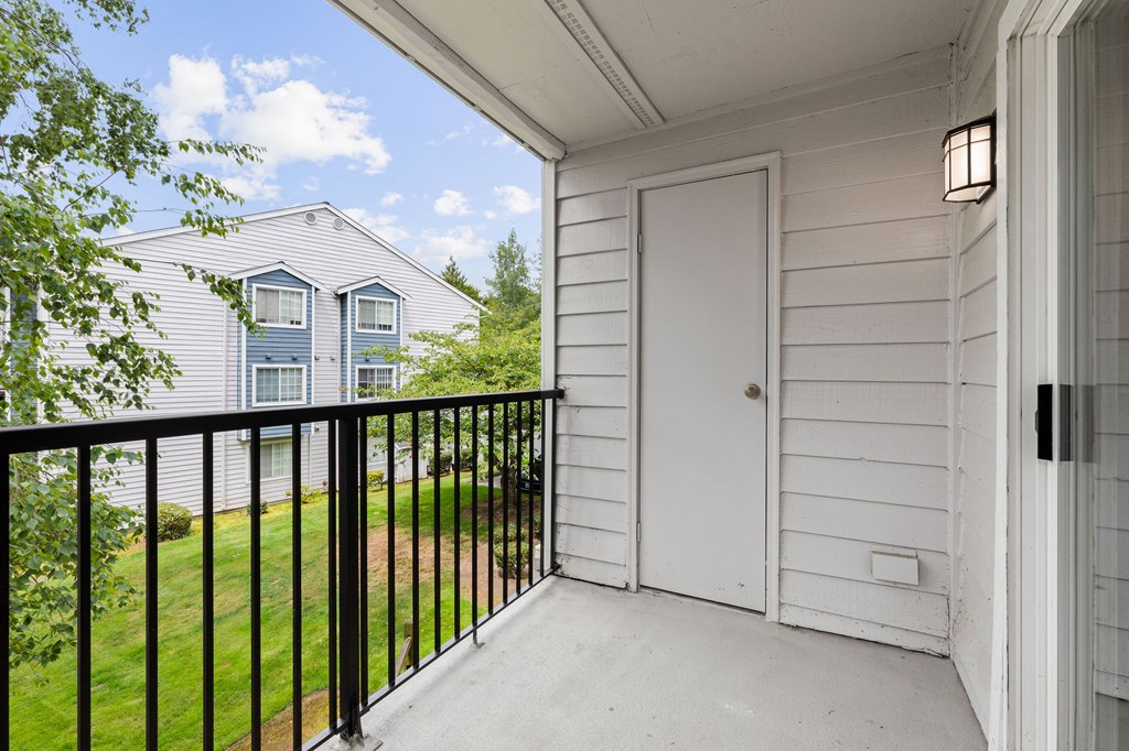 A white door is on the porch of a house.