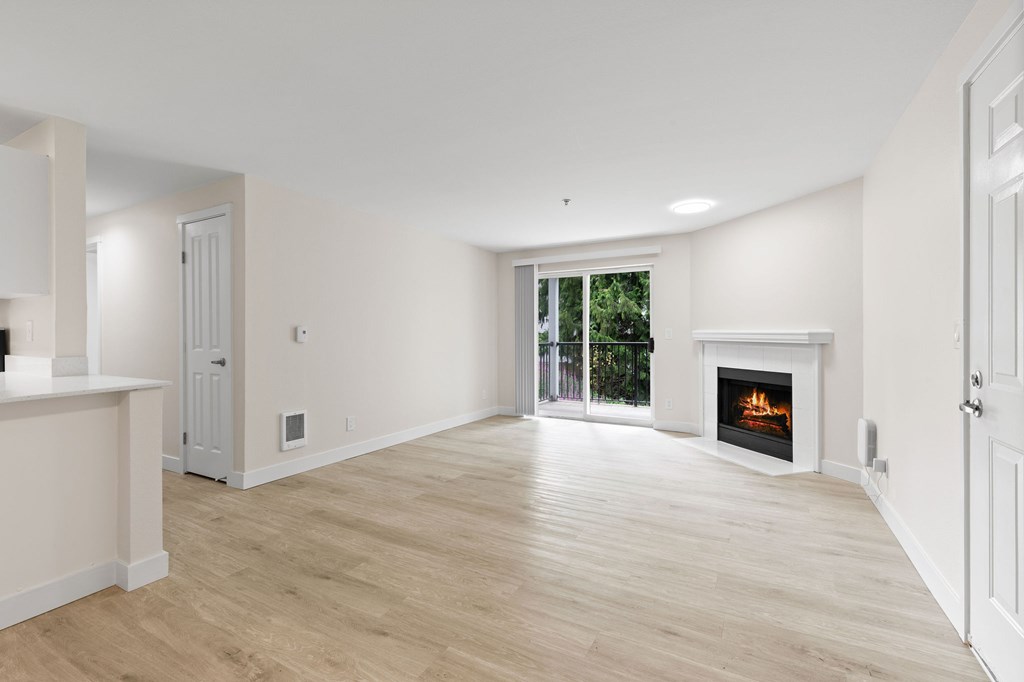 A spacious living room with a fireplace and sliding glass doors.