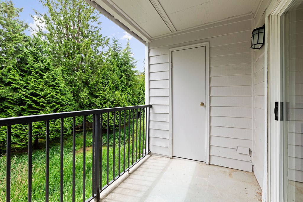 A white door is on the right side of a porch.