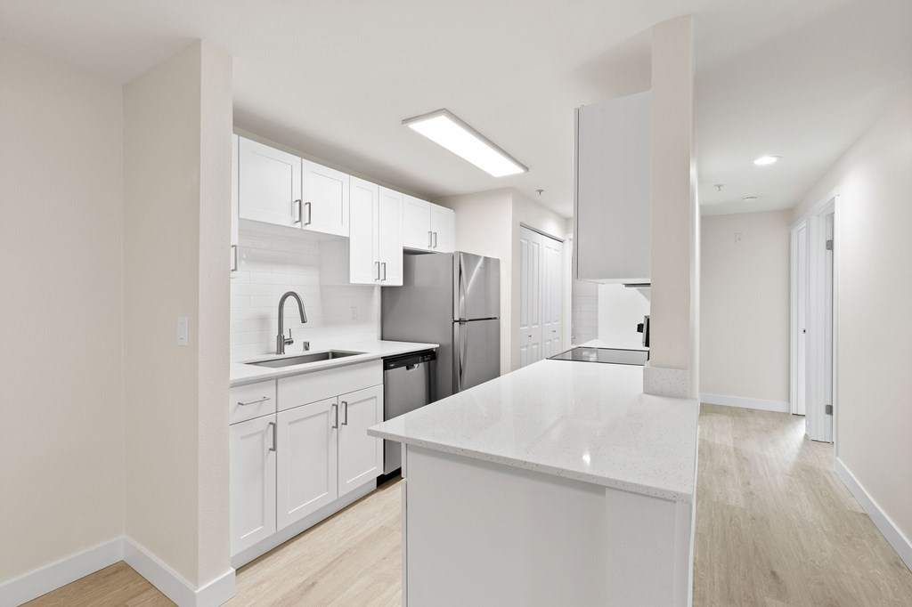 A modern kitchen with white cabinets and appliances.