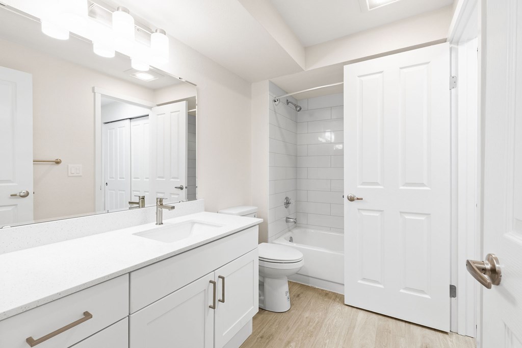 A white bathroom with a toilet, sink, and bathtub.