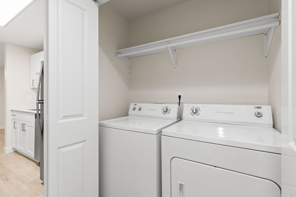A white laundry room with a washer and dryer.