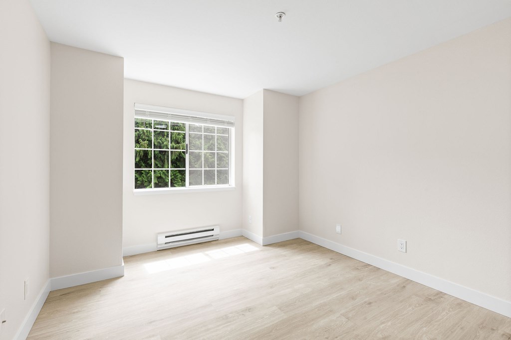 A room with a window and a wall-mounted air conditioner.