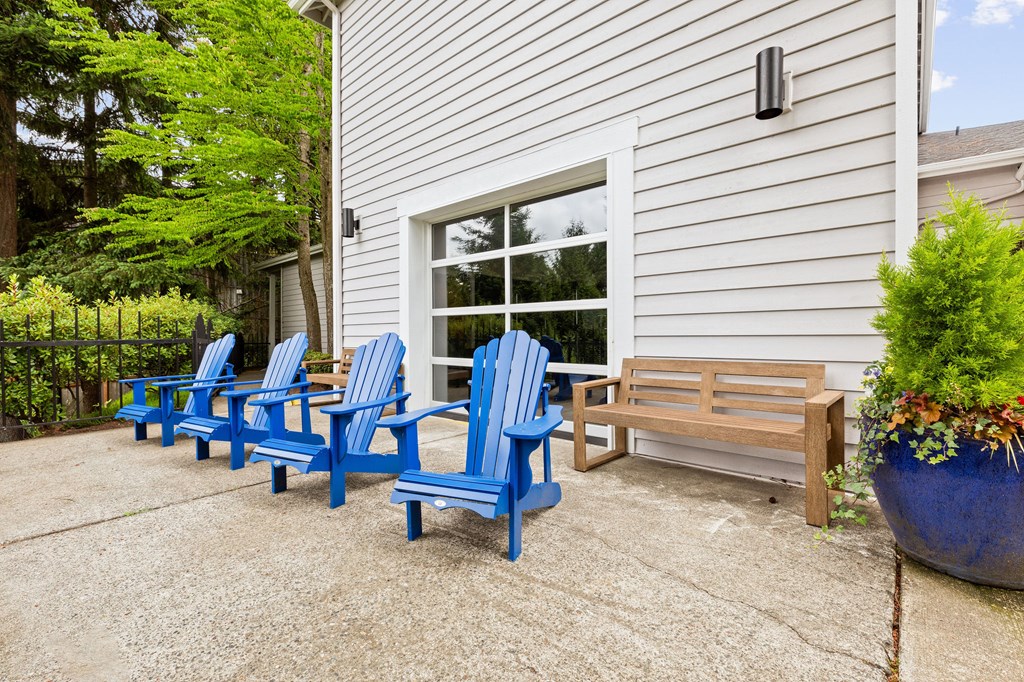 A set of blue chairs are arranged on a patio.
