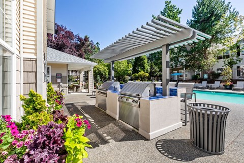 A poolside area with a trash can and a trash can cover.