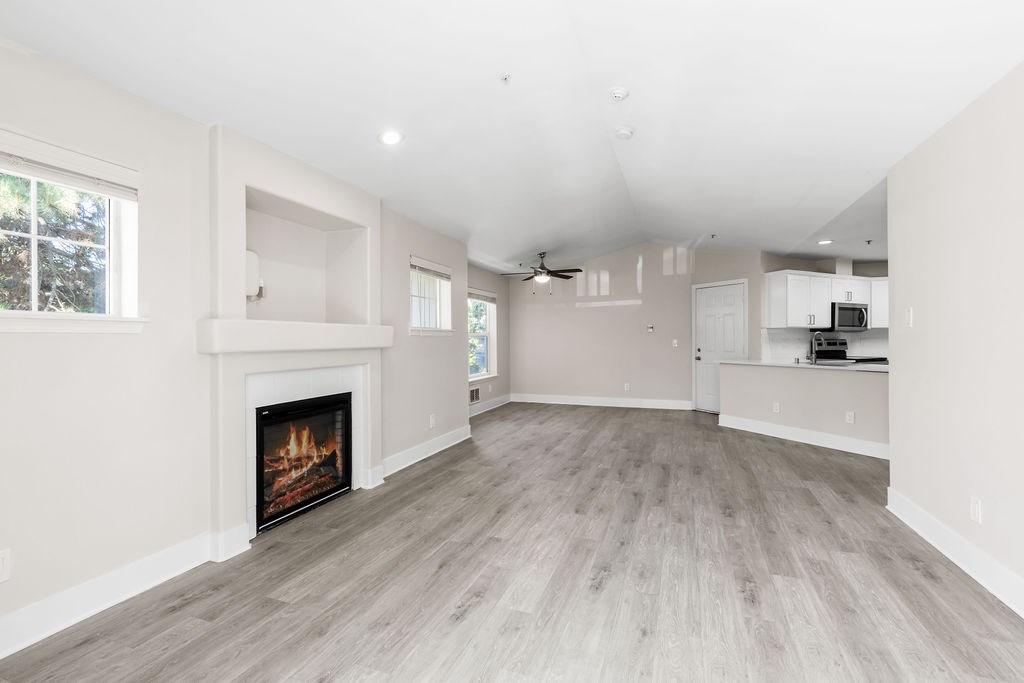 A spacious living room with a fireplace and hardwood floors.