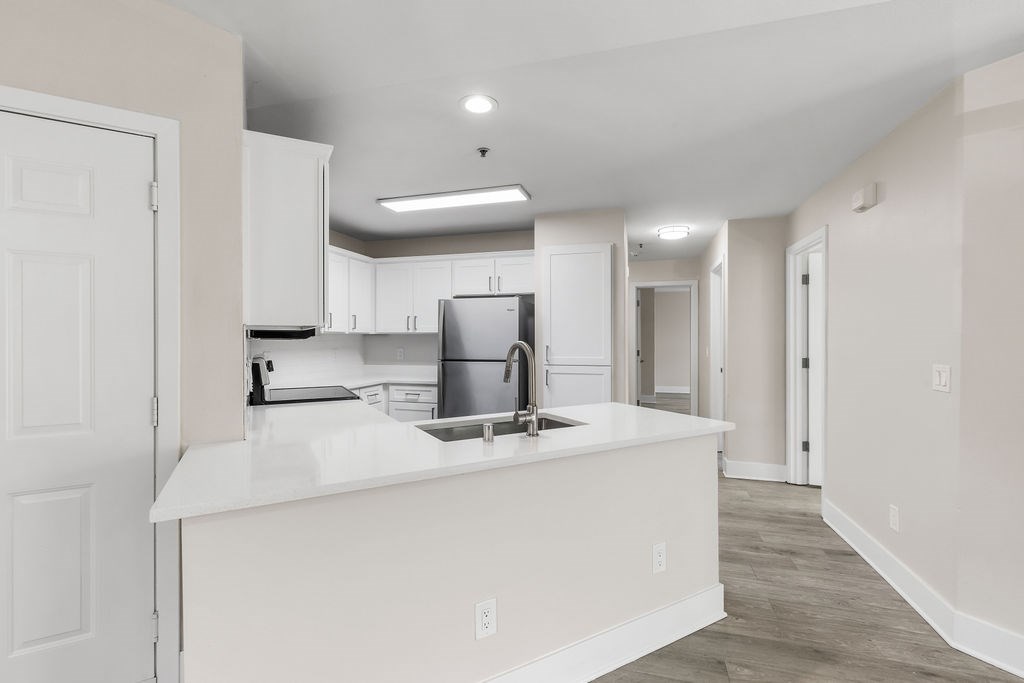 A kitchen with white cabinets and a white countertop.