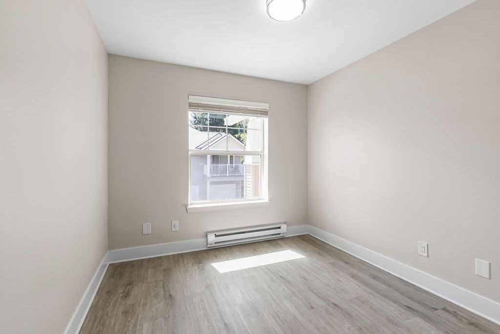 A room with a window and a radiator on the wall.