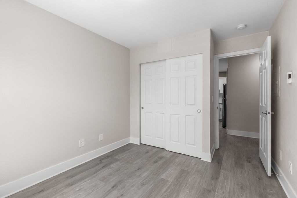 A room with a white door and a grey floor.