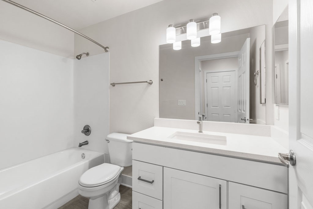 A white bathroom with a toilet, sink, and bathtub.