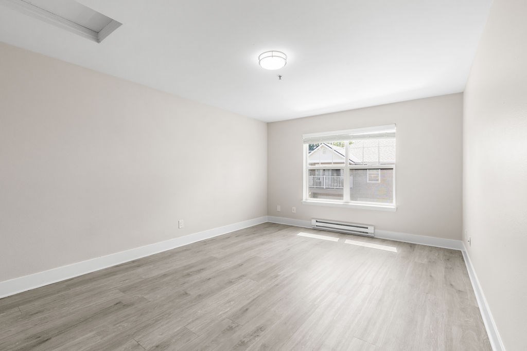 A room with a window and a wooden floor.
