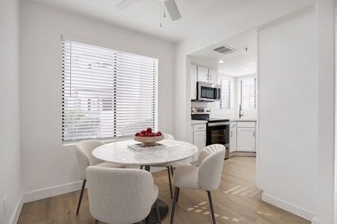 A white dining room with a table and chairs.