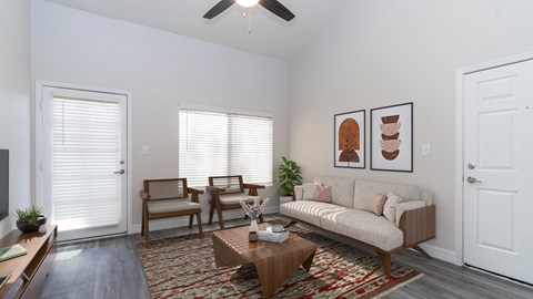 a living room with two windows and a ceiling fan