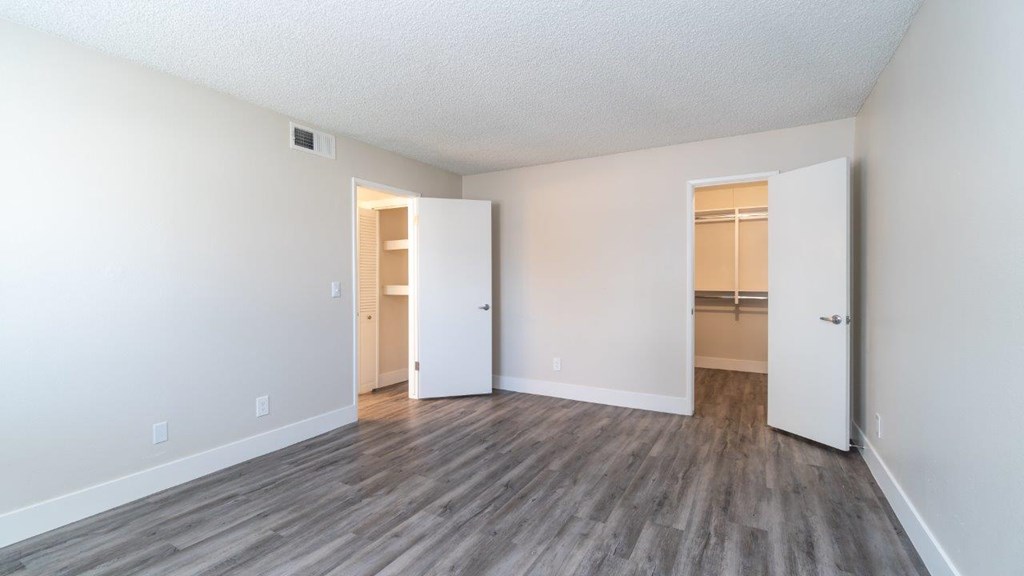 A room with a wooden floor and two white doors.