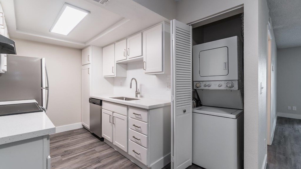 A kitchen with white cabinets and appliances.