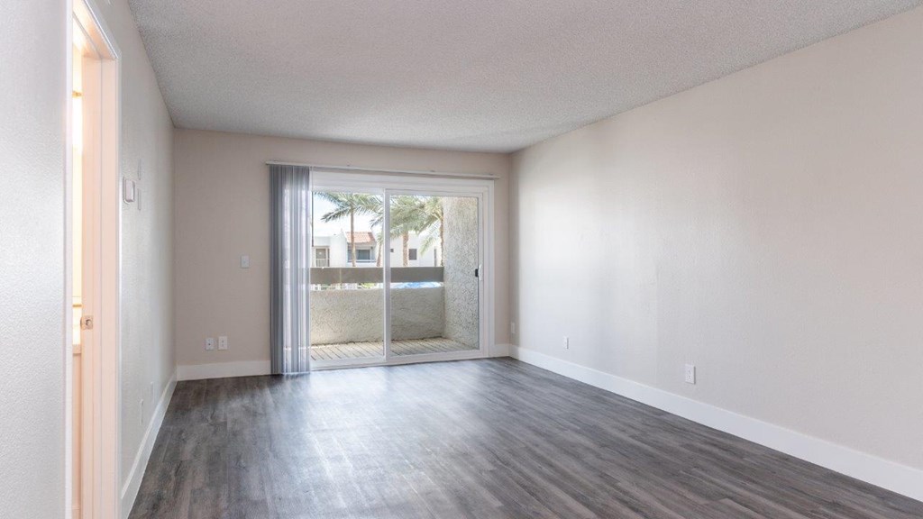 A room with a sliding glass door leading to a balcony.